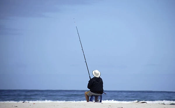 A man fishes at the beach at Bettys Bay near Kleinmond