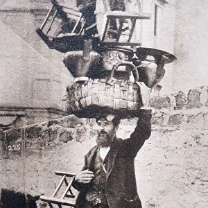 Man Balancing Basket and Chairs on His Head