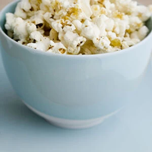Freshly popped pocorn in pretty blue bowl credit: Marie-Louise Avery / thePictureKitchen