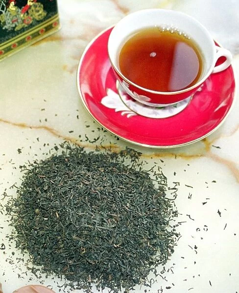 Cup of black tea with tea leaves