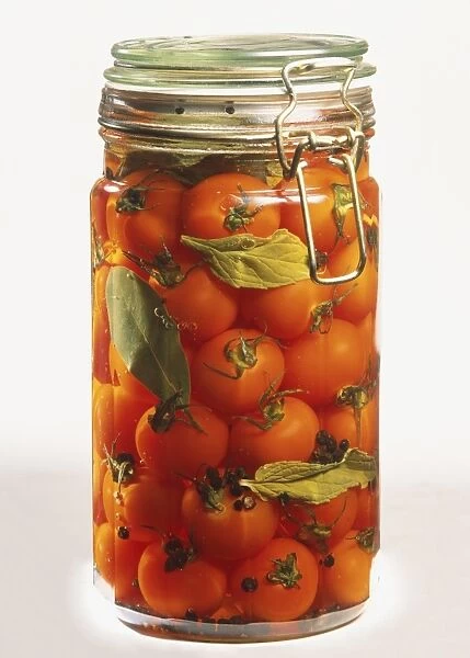 Glass jar of preserved red cherry tomatoes