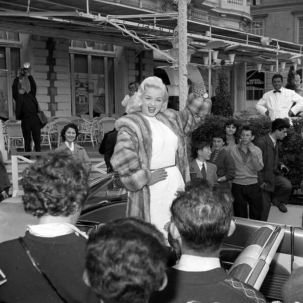 Actress Diana Dors waves to spectators and photographers on her arrival at the Cannes