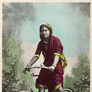 Studio portrait, Hindu woman riding a bicycle, India