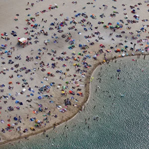 An aerial view shows people at a beach on the shores of lake Silbersee on a hot summer