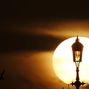 The sun sets behind a lamp in London