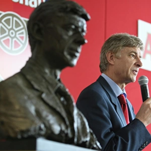 Arsene Wenger the Arsenal Manager standing next to his bust