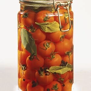 Glass jar of preserved red cherry tomatoes