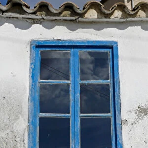Blue framed window in white wall of Greek Cypriot house credit: Marie-Louise Avery