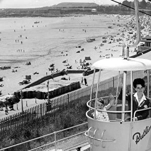 13 June 1967 A redcoat and a camper enjoy a ride in the Butlins rope railway high above